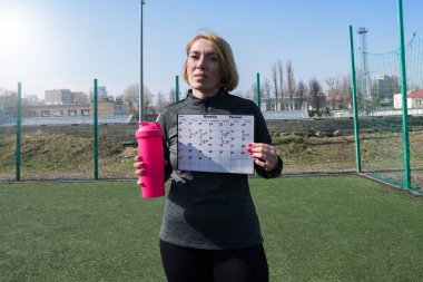 Stadyumda spor antrenmanı programı olan bir kadın. Açık antrenman koçu, eğitim programları ve fitness programları