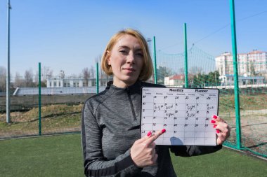 Stadyumda spor antrenmanı programı olan bir kadın. Açık antrenman koçu, eğitim programları ve fitness programları