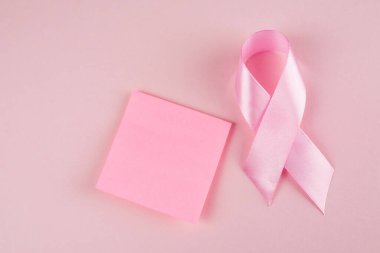 Pembe kurdele ve pembe arka planda boş etiket. Dünya Göğüs Kanseri Günü.