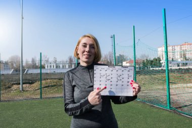 Stadyumda spor antrenmanı programı olan bir kadın. Açık antrenman koçu, eğitim programları ve fitness programları