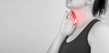 Boğazı ağrıyan, boynu ağrıyan, boş yere dokunan, siyah beyaz fotoğraf çeken bir kadının yakın çekimi.