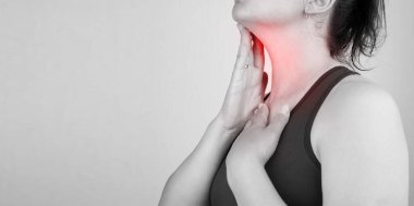 Boğazı ağrıyan, boynu ağrıyan, boş yere dokunan, siyah beyaz fotoğraf çeken bir kadının yakın çekimi.