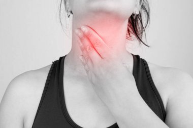 Boğazı ağrıyan, boynu ağrıyan, boş yere dokunan, siyah beyaz fotoğraf çeken bir kadının yakın çekimi.