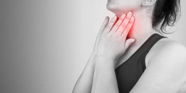 Boğazı ağrıyan, boynu ağrıyan, boş yere dokunan, siyah beyaz fotoğraf çeken bir kadının yakın çekimi.