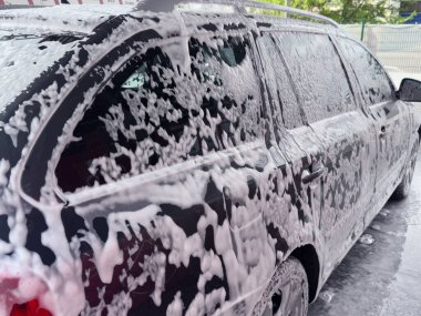 Oto yıkamada köpükle kaplı bir arabanın yakın çekimi..