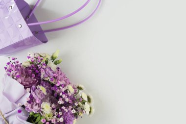 Farklı mor çiçeklerden oluşan bir buket hediye, beyaz arka plan. Bayram hediyesi, Kadınlar Günü, Düğün, Anneler Günü, 8 Mart. Hediye paketinde çiçek aranjmanı. Şablon.