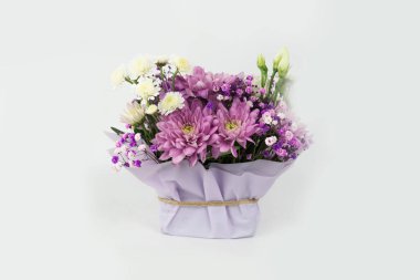 Farklı mor çiçeklerden oluşan bir buket hediye, beyaz arka plan. Bayram hediyesi, Kadınlar Günü, Düğün, Anneler Günü, 8 Mart. Hediye paketinde çiçek aranjmanı. Şablon.