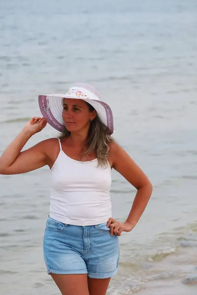 Beyaz şapkalı ve siyah elbiseli genç kız.