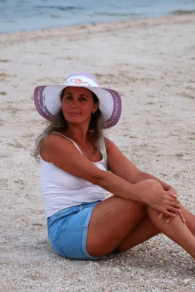 Kumsalda dinlenen bir kadın