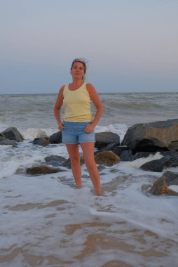  Bir kadın kıyı şeridinde oturur ve yürür. Yazın, ilkbaharda duygular olur. İlkbaharda gökyüzüne bakar. 