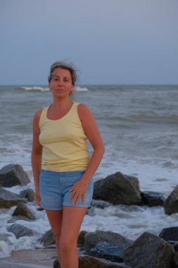 Plajdaki beyaz tişörtlü kadın.