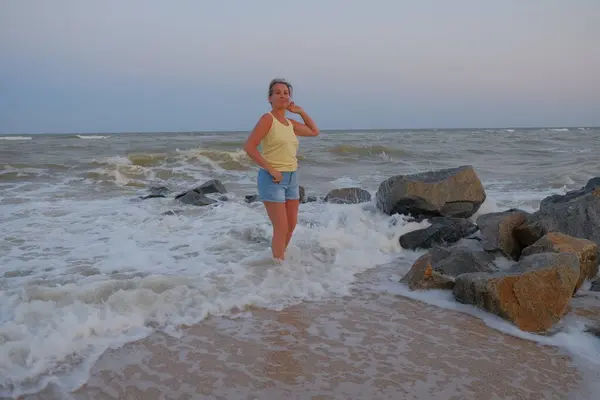 Kız deniz kıyısında yürüyor. Kız deniz kıyısında oturuyor..