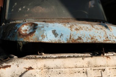 Büyük bir pencerenin önünde eski bir traktörle paslı bir traktör.