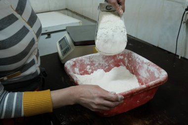 Fırında pişirmek için un yoğuran kadın.