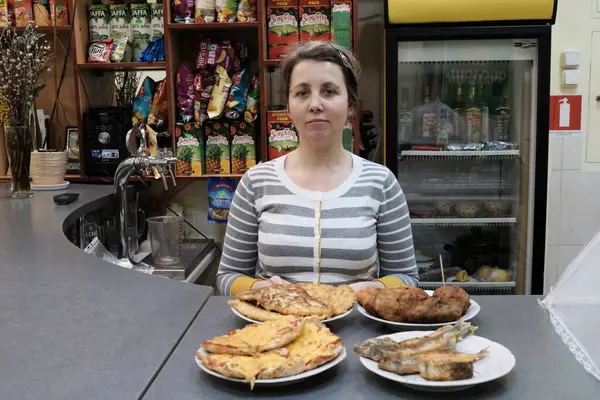 Markette elinde tavuk ve patates kızartması olan bir kadın..