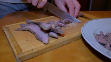 Biftek dilimleyen kadın ve kesme tahtasındaki domuz eti insanların elleri ve ürünler görülebilir durumda. Yüksek kalite 4k görüntü