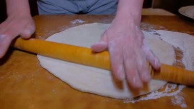 Evdeki kadın hamur yoğurarak pizzayı görünür hale getiriyor. İnsan eli ürünü görünür kılıyor. Masanın üzerindeki tüm eylemler.