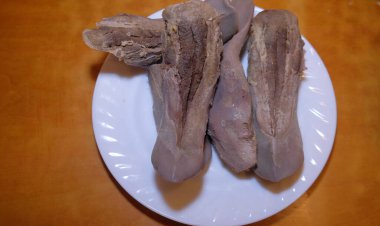 Beyaz tabakta sığır eti dili ve kahverengi bir masa, çeşitli ürünler çok güzel bir şekilde sunuluyor. Yüksek kalite fotoğraf