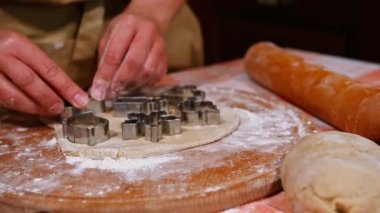 Bir aşçı, bir fırıncı kadın hamuru çıkarıyor ve Noel için zencefilli kurabiye kalıpları kesiyor. Pastane şekerlemesi. Noel zamanı. Kış tatili