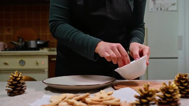 黒いキッチンエプロンのシェフのお菓子 焼きたてのジンジャーブレッドクッキーをチョコレートに浸します クリスマスのお祝いのベーキングアイテム 料理菓子パン屋 — ストック動画