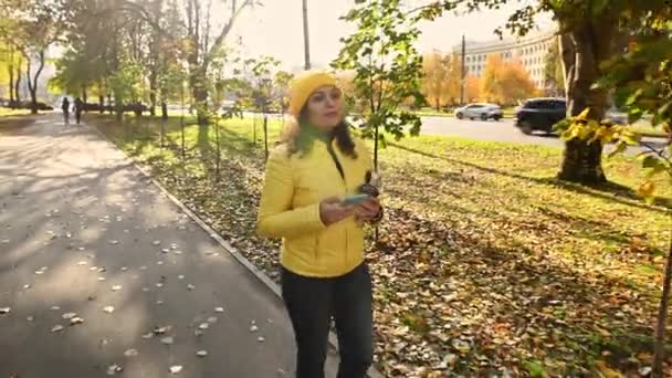 Feliz Mujer Sonriente Con Chaqueta Sombrero Amarillo Brillante Caminando Por — Vídeo de stock