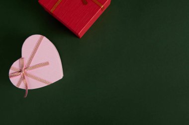 Yeşil arka planda pembe renkli hediye kutularıyla dolu bir hayat. Boks günü. Sevgililer Günü ve Kadınlar Günü. Reklam alanını kopyala