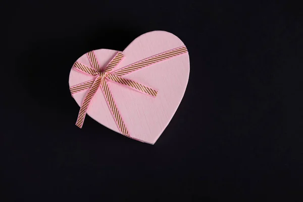 安静的生活 平铺构图与心形粉红色礼品盒捆绑弓 隔离在黑色背景与复制广告空间 情人节或妇女日的浪漫礼物 — 图库照片
