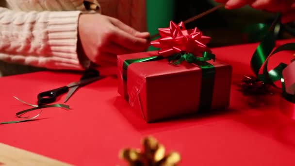 Nahaufnahme Frauenhände Mit Geschenkband Klebeband Und Geschenk Geschenkpapier Auf Rotem — Stockvideo