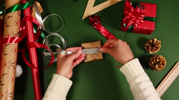 Top Kilátás Megkötni Egy Karácsonyi Ajándék Fehér Szalaggal Zöld Háttér — Stock videók