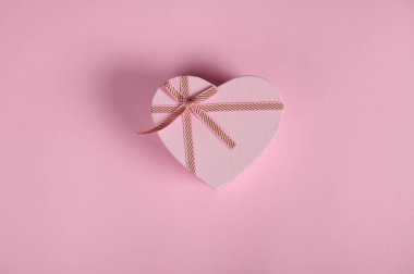 Sevgililer Günü 'nde kalp şeklinde bir kutuda sevgililer günü hediyesiyle yatıyordu. 14 Şubat. Pembe arka planda fotokopi reklam alanı olan bir hayat. 8 Mart 'ta Kadınlar Günü için Romantik Hediye