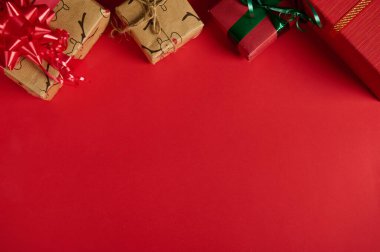 Kırmızı arka planda hediyelerle dolu bir Noel. Uzayı kopyala. Model, promosyon metni için tasarım. Boks Günü. Xmas ve yeni yıl hazırlıkları. Hediyeleri paketliyorum. Web afişi. Düz yatıyordu