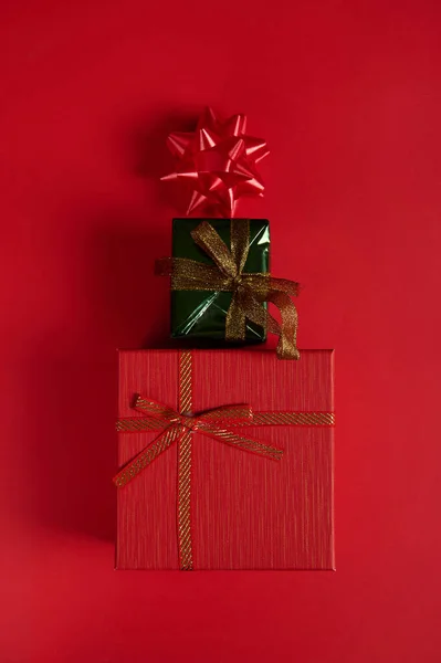 平躺在床上垂直工作室拍摄的可爱时尚礼品盒 摆设成圣诞树的形状 装饰着红色背景的蝴蝶结 安静的生活 新年活动 节礼日12月25日圣诞节 — 图库照片