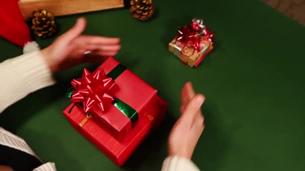 クリスマスツリーの形をしたクリスマスプレゼント箱を1つずつ積み上げ コピー広告スペースがある緑の背景でそれらを一周する女性の上の眺め ボクシングの日 包装プレゼント — ストック動画