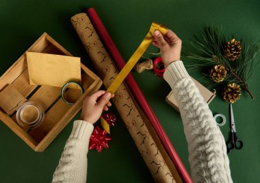 Üst görüntüde altın bir bant var. Noel ve yeni yıl hediyelerini paketliyorum. Boks günü. Mutlu bayramlar, sürpriz. Sihir zamanı. Kış kutlamaları. El işi sanatları.