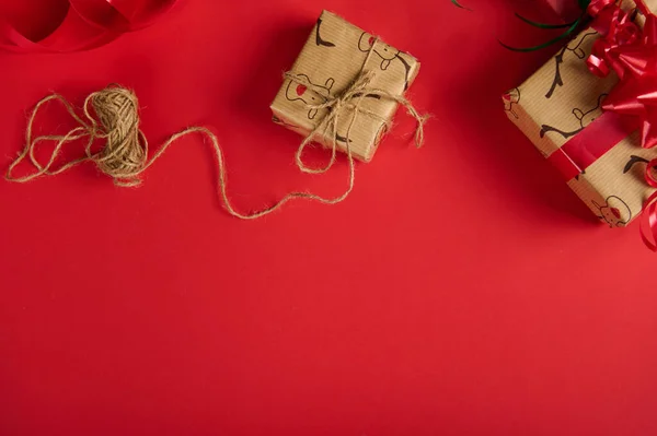 精美的礼物 用鹿纹的包装纸包裹着 用亚麻绳和红色的带子捆着 上面有红色的背景和复制的广告空间 圣诞及新年准备工作 — 图库照片