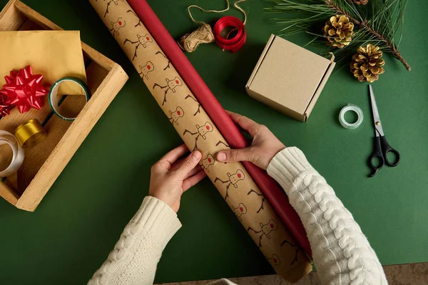 顶部视图手拿着包装纸绿色的背景与装饰材料 为迪米礼物 新年和圣诞节的准备工作 手工艺术 包装礼物 节礼日神奇的心情 — 图库照片