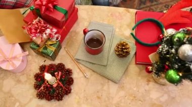 Mutlu hediyelerle dolu mermer bir masa, süslü bir Noel ağacı, yanan bir mum. Yeni yıl hazırlıkları. İyi tatiller. Sihirli ruh hali. Kablo çekimi
