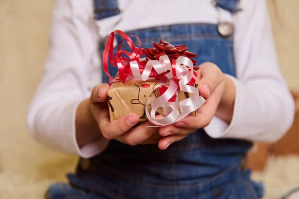Kind Trägt Jeans Overalls Und Hält Weihnachtsgeschenk Der Hand Nahaufnahme — Stockfoto