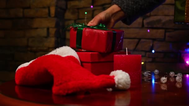 Großaufnahme Von Frauenhänden Die Eine Rote Deko Kerze Und Weihnachtsgeschenke — Stockvideo