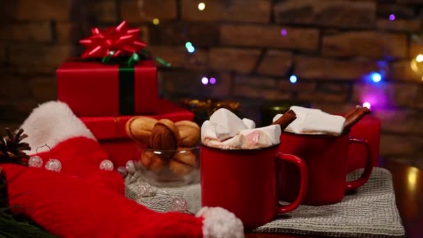 Kırmızı Bardaklara Sıcak Çikolatalı Içeceğe Marşmelovlara Noel Hediyeli Ahşap Masaya — Stok video