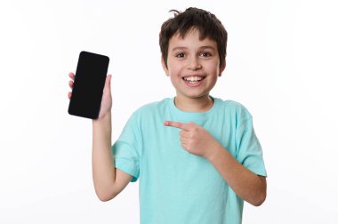 Vay canına. Harika mobil uygulama. Yakışıklı beyaz çocuk, genç reklam metinleri için siyah ekranı olan akıllı telefonu işaret ediyor. Kameraya gülümsüyor, beyaz arkaplanda poz veriyor.