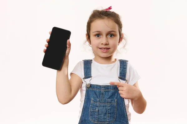 Zajebista Aplikacja Mobilna Urocza Radosna Dziewczynka Wskazuje Smartfona Czarnym Czystym — Zdjęcie stockowe