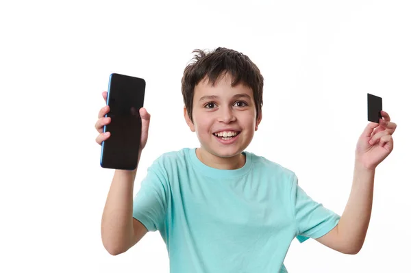 Happy Overjoyed Przystojny Nastolatek Trzyma Smartfona Karty Atm Przestrzeni Reklamowej — Zdjęcie stockowe