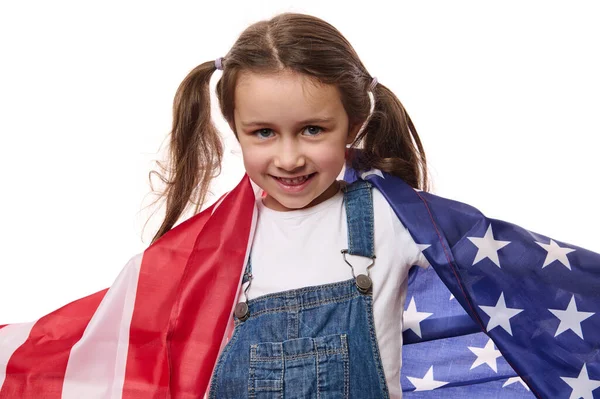 Küçük mutlu bir Amerikan vatandaşı, mavi kot pantolon giymiş şirin bir kız çocuğu, Amerikan bayrağıyla, 4 Temmuz 'da Bağımsızlık Günü' nü kutluyor, beyaz arka planda izole edilmiş. Göçmenlik, vatandaşlık ve özgürlük kavramı