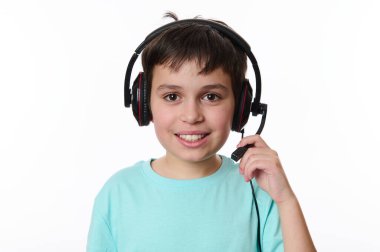 Yakışıklı beyaz bir öğrencinin yakın plan portresi, ses kulaklığı takan, çevrimiçi derse hazır, kameraya dikkatlice bakan, beyaz arka planda izole edilmiş. Uzayı kopyala