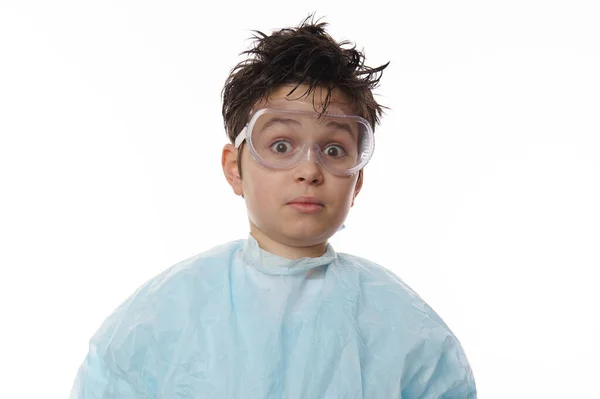 stock image Close-up studio shot of an amazed smart teenage boy, nerd chemist scientist in labwear and goggles, looking at camera with astonishment, isolated on white background with free advertising space