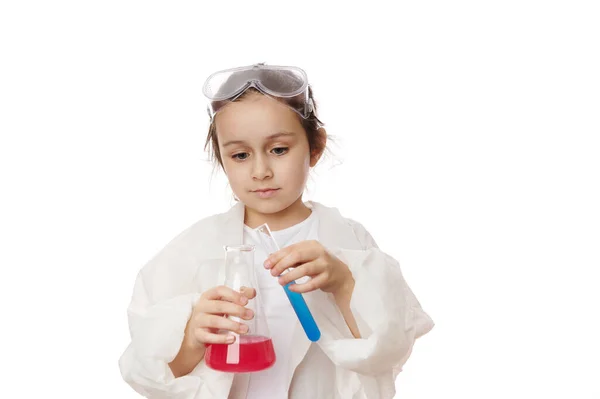 研究室のコートに白人のいたずらな少女の手 実験室の試験管と化学物質や試薬とフラスコを保持 起こっている化学反応を見て 白い壁に隔離された — ストック写真