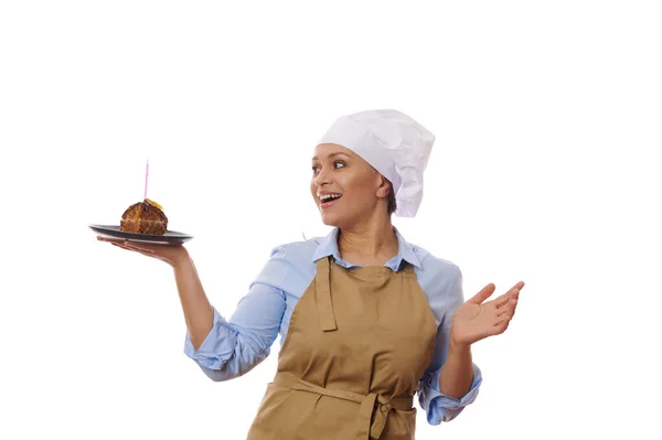 배경에 고립된 요리사는 베이지 앞치마를 양초를 집에서 초콜릿 케이크를 보면서 — 스톡 사진