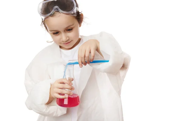 美しい子供の女の子 小さな化学者 科学者は白い背景に隔離された化学溶液でフラスコに試験管からいくつかの試薬を注ぎます 子供たちの初期の開発 化学だ 広告スペースのコピー — ストック写真