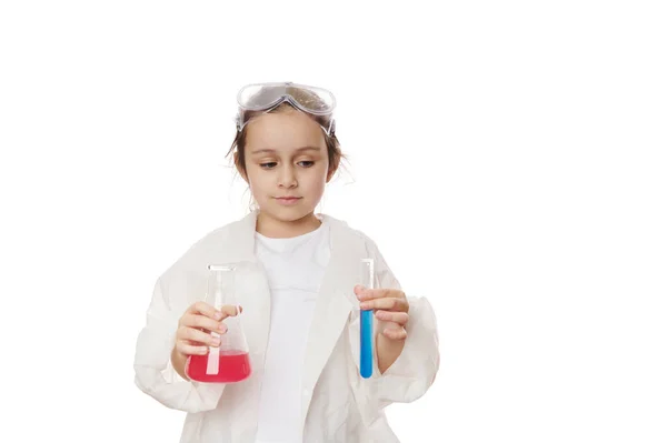 スマート小学生 女の子の化学者科学者は 化学クラスを楽しんで 白い背景にカラフルな化学溶液を持つ実験室のフラスコと試験管を保持しています 広告スペースのコピー — ストック写真